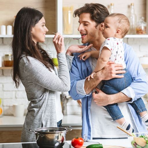 young couple with their baby in a kitchen setting