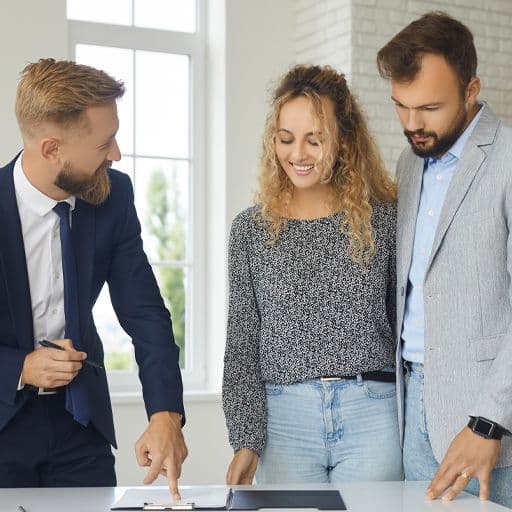 couple viewing a property with an estate agent preparing to sign a contract