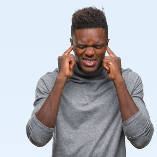 man with his fingers in his ears