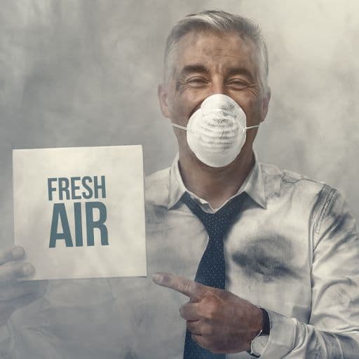 man covered in dust wearing a face mask holding a sign saying fresh air