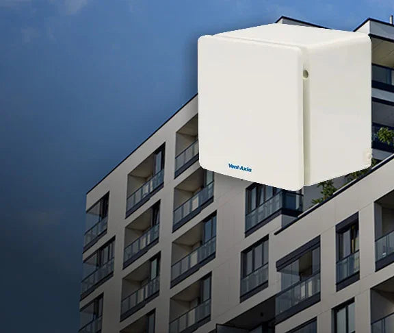 White air conditioning unit on the exterior wall of a building with a blue sky background