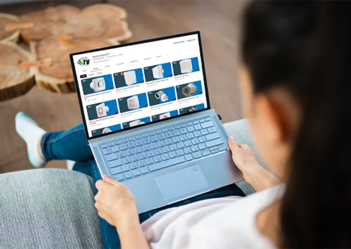 Person using a laptop with a screen displaying a product catalog on a blurred background